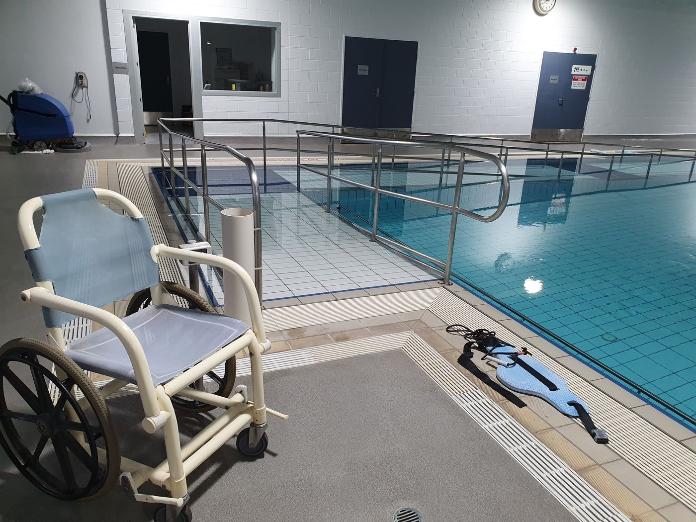 A pool wheelchair beside the ramp into the water